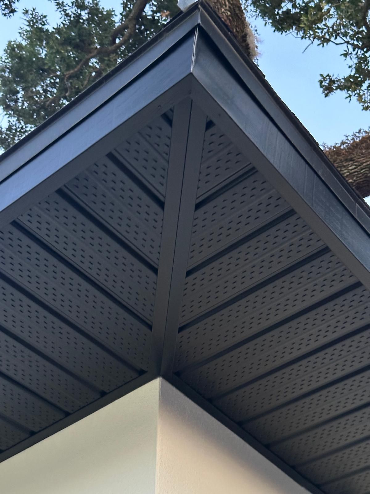 A close up of a roof with a tree in the background