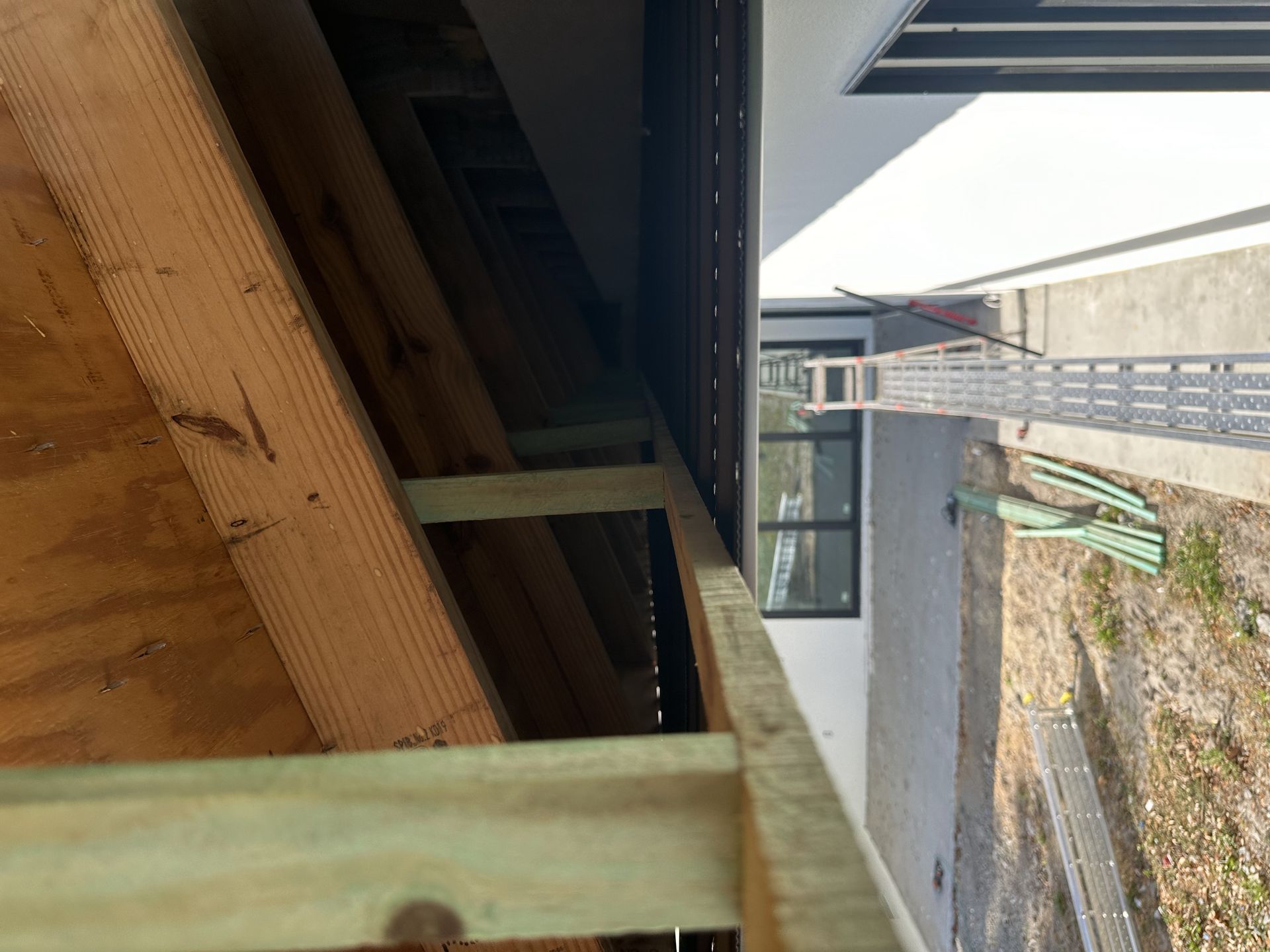 A ladder is hanging from the ceiling of a building under construction.