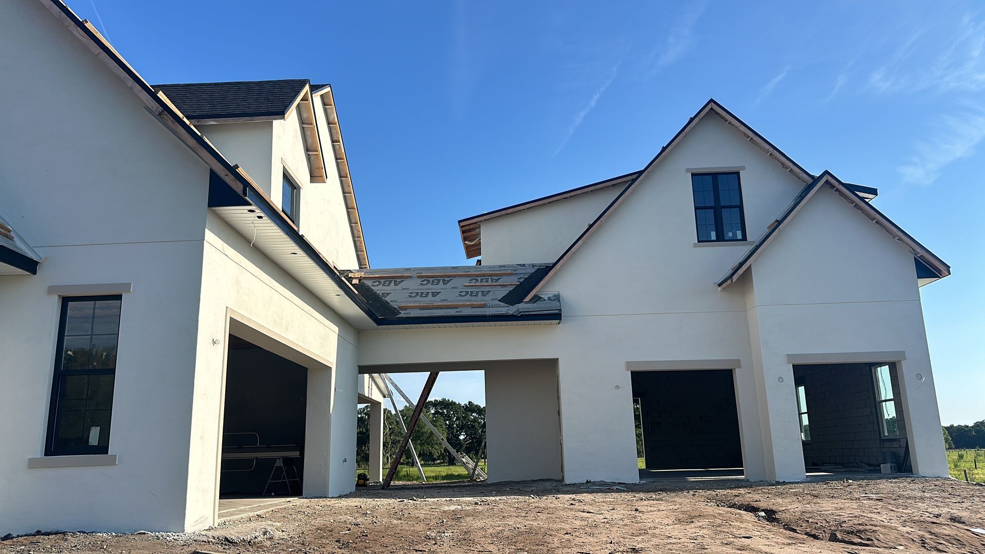 A white house with black windows and a blue sky in the background