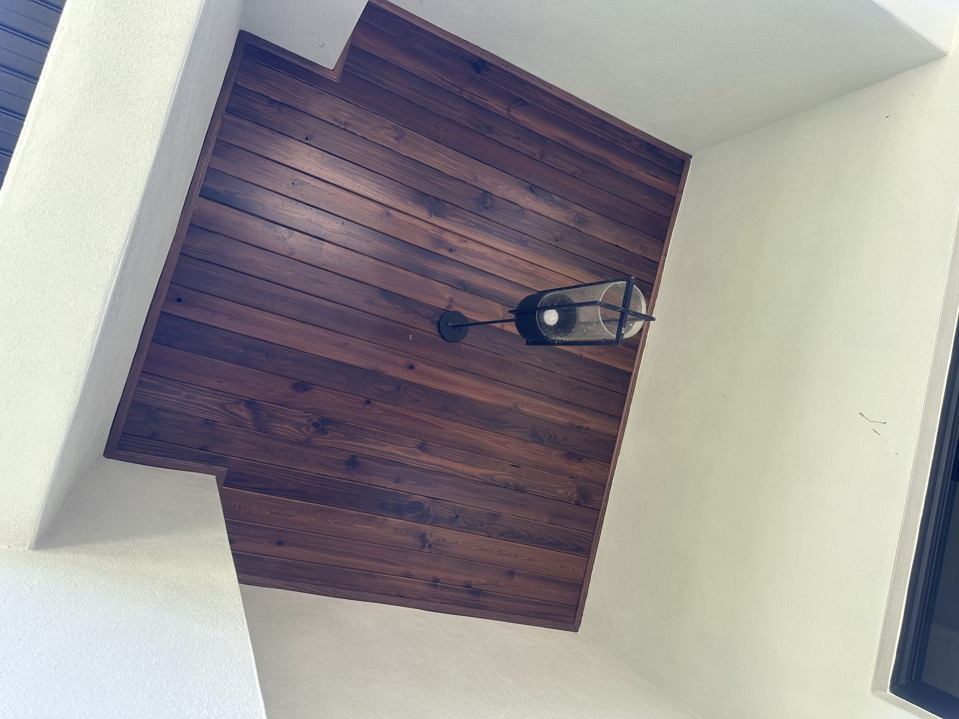 A wooden ceiling with a light hanging from it