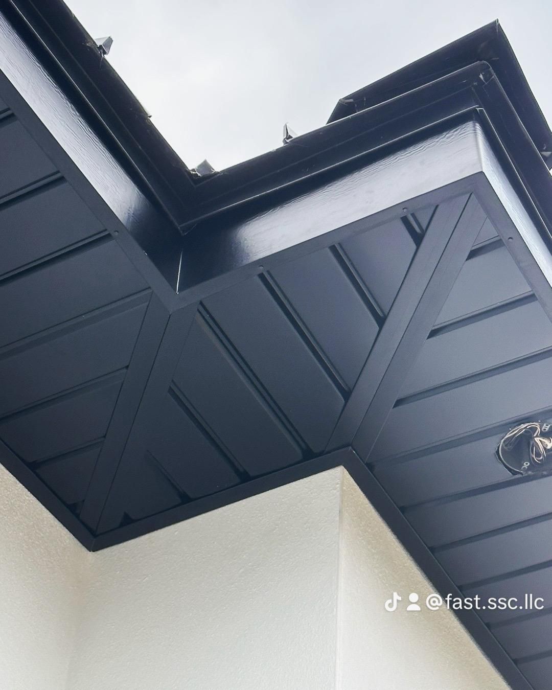 A close up of a black roof with a clock on it