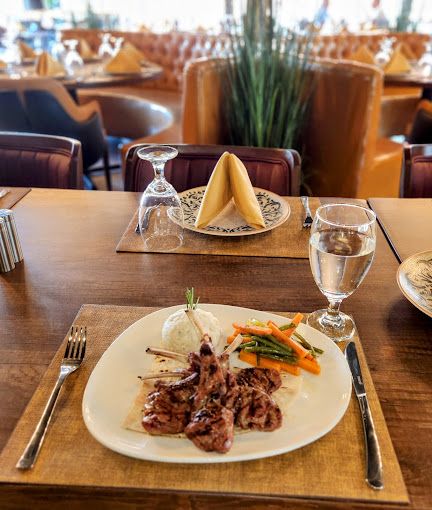 A plate of food and a glass of water on a table in a restaurant.