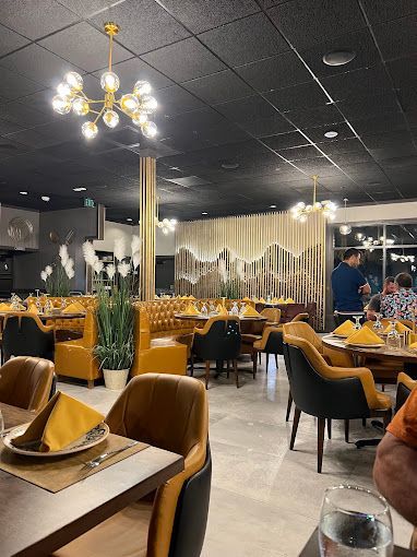 A restaurant filled with tables and chairs and a glass of water.