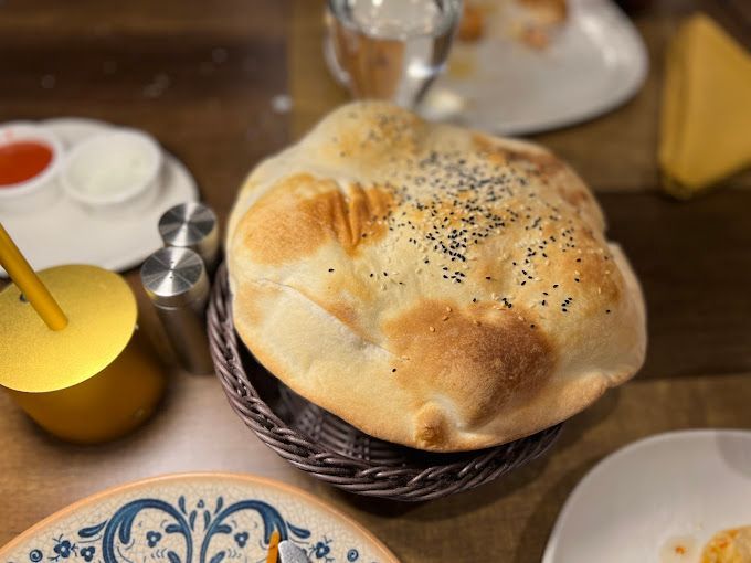 A loaf of bread is in a basket on a table.