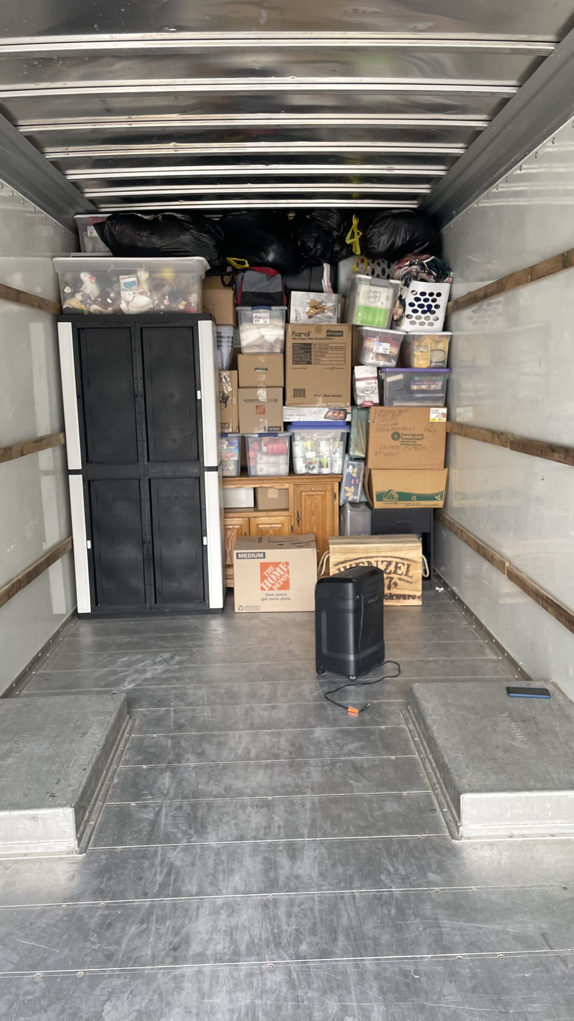Inside a moving truck, packed with furniture, boxes, and assorted items ready for transport.