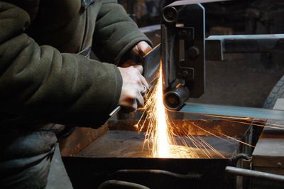 A person is grinding a piece of metal with a machine