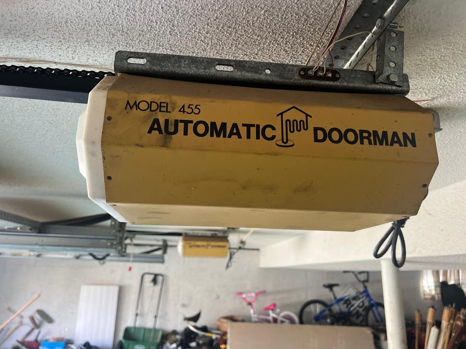 Yellow Automatic Doorman Model 455 garage door opener mounted on the ceiling.