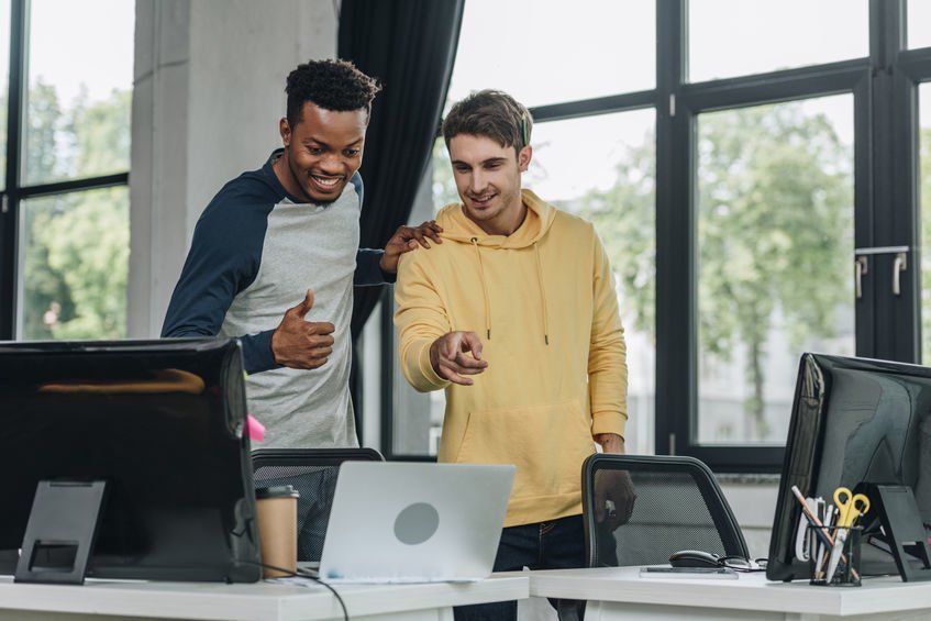 Two male IT technicians expressing their success in solving an IT support problem.