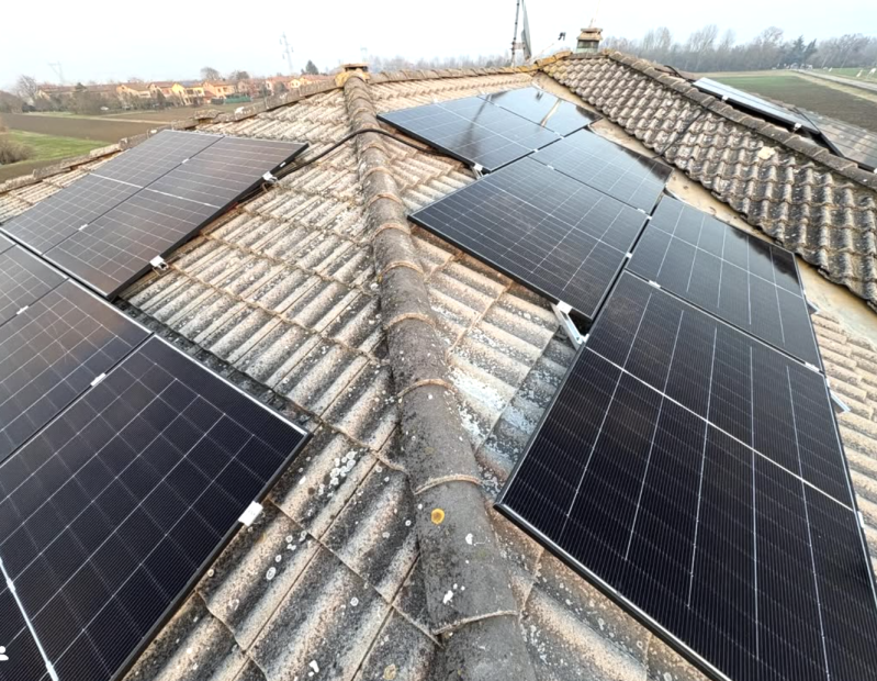 Un tecnico utilizza un amperometro a pinza per misurare la corrente nei cavi elettrici all'interno di un quadro elettrico.