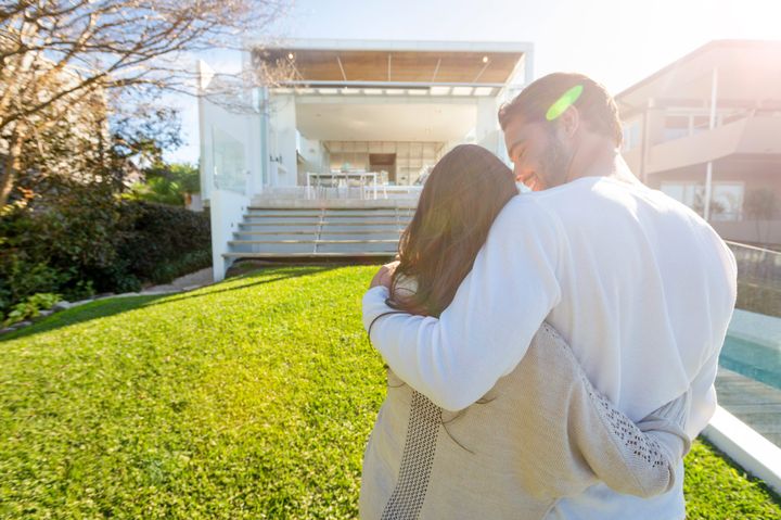 Couple standing in front of a modern house — Sacramento, CA — Devereaux Estate Law, PC