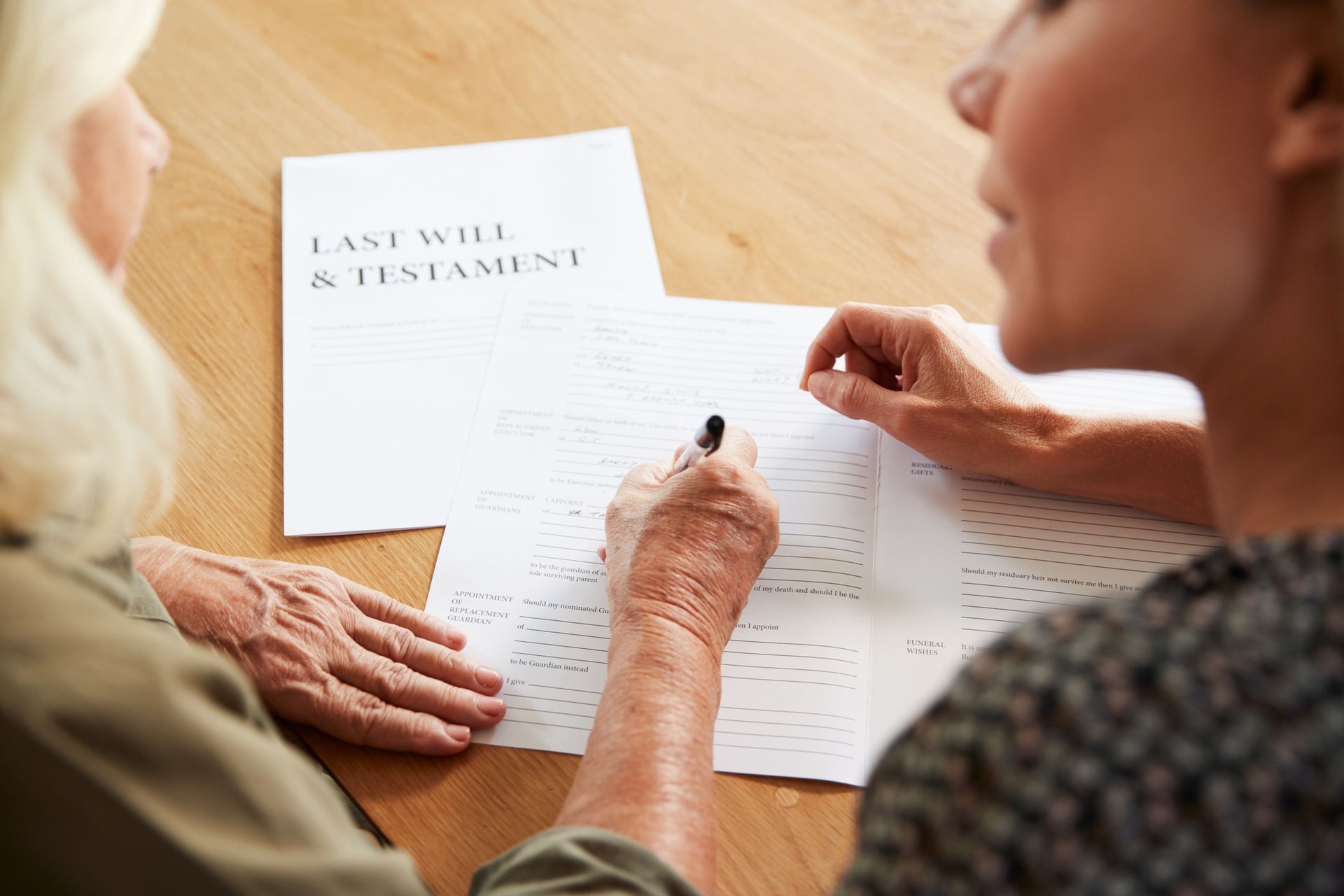 Probate attorney assisting senior woman with last will and testament at home