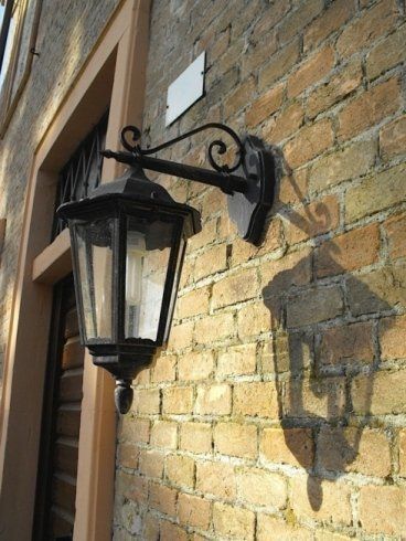 Bella fotografia della lanterna impiccando della parete e la sua ombra