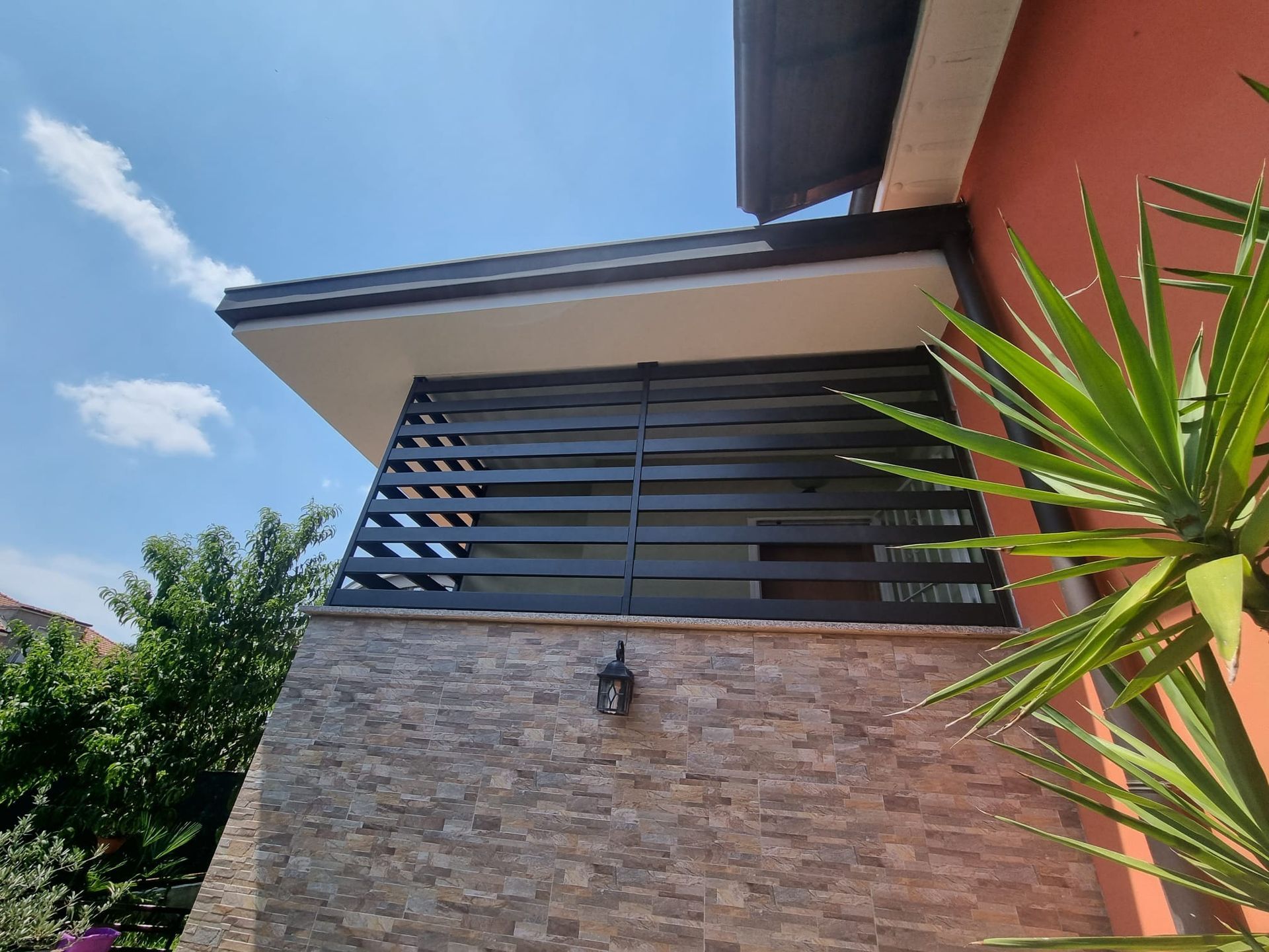 Vista esterna di un edificio con una recinzione a listelli neri 