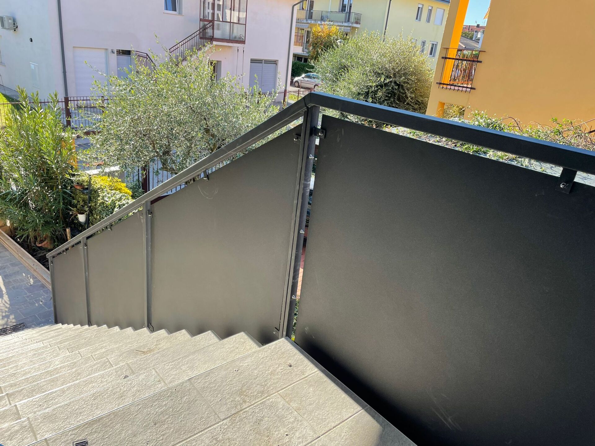 Scala esterna con ringhiera e schermatura in metallo grigio scuro.