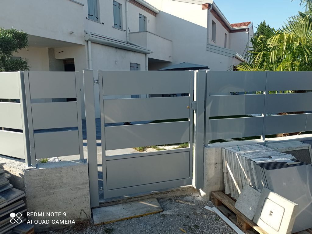 Un cancello e una recinzione in metallo grigio chiaro 