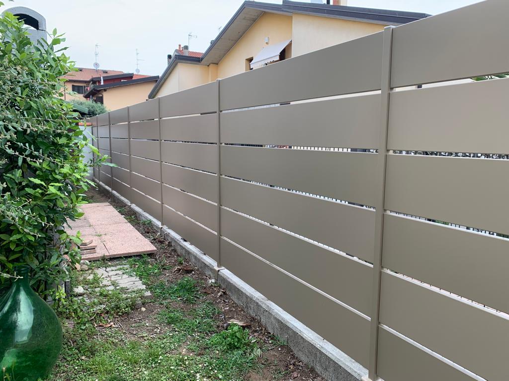 Recinzione a doghe orizzontali color marrone chiaro in un cortile.