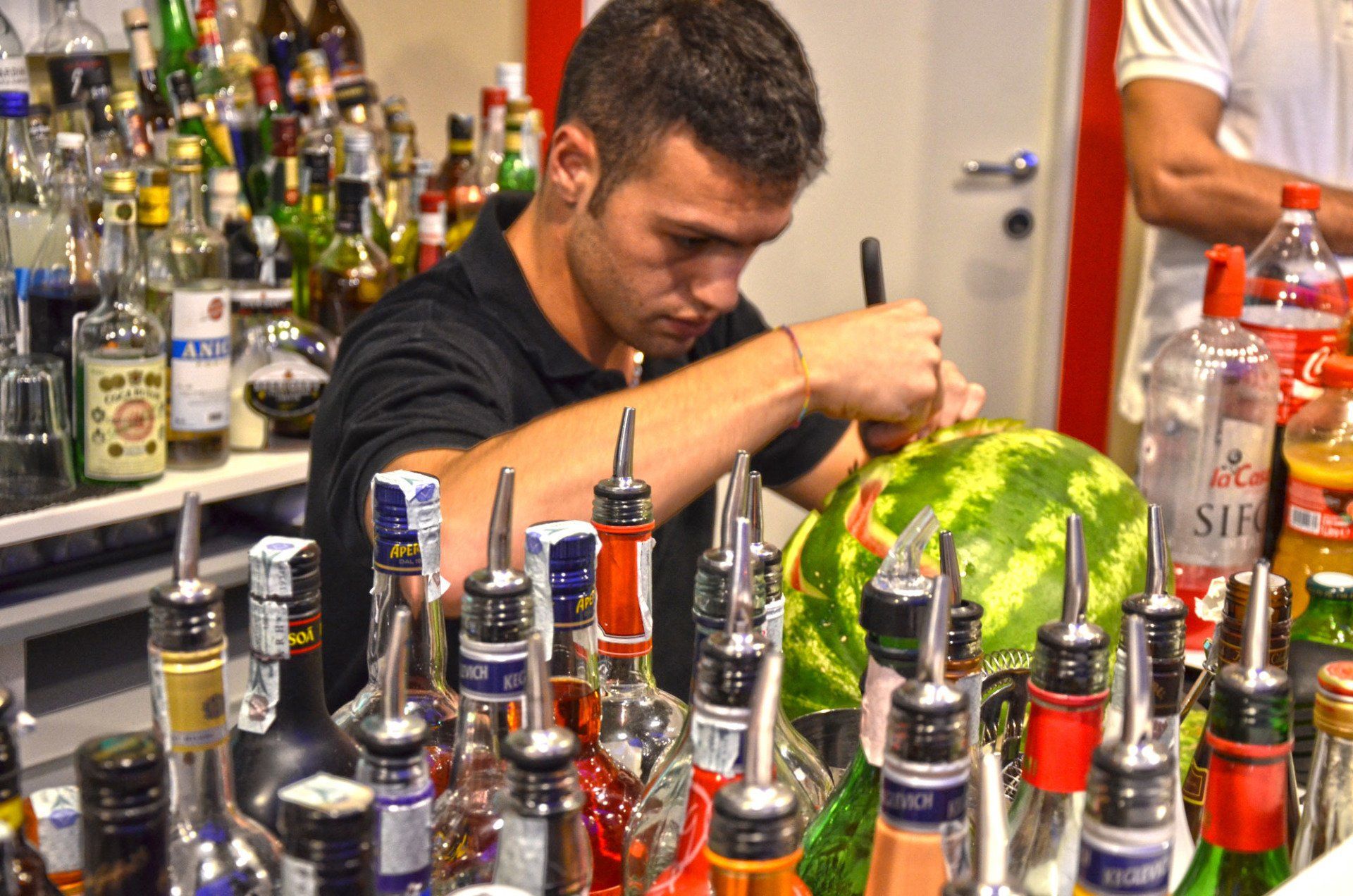 Un barman che prepara dei cocktail a base di frutta fresca