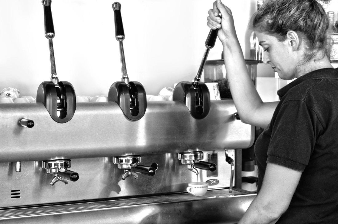 Un barista che prepara un caffè espresso con macchinetta professionale