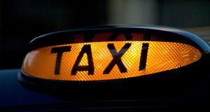 A large illuminated TAXI Sign