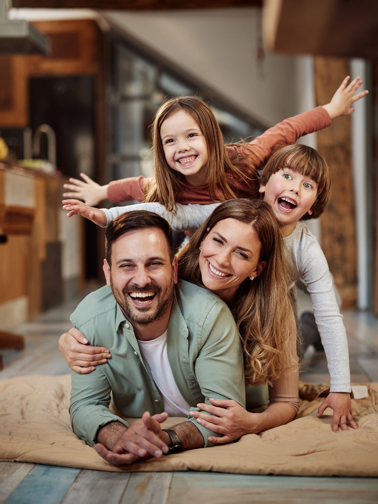 A family is laying on a rug on the floor.