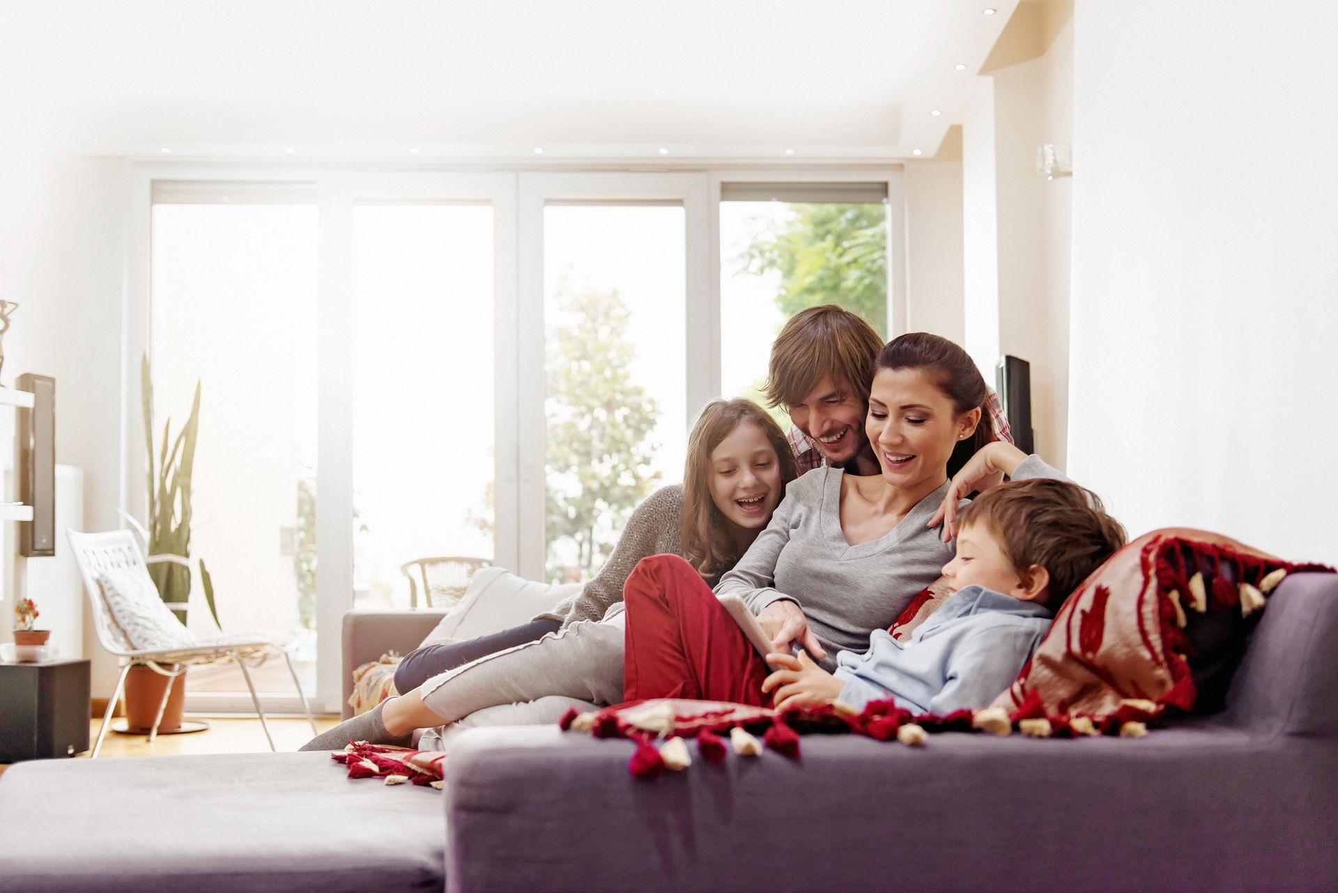 A family is sitting on a couch in a living room.