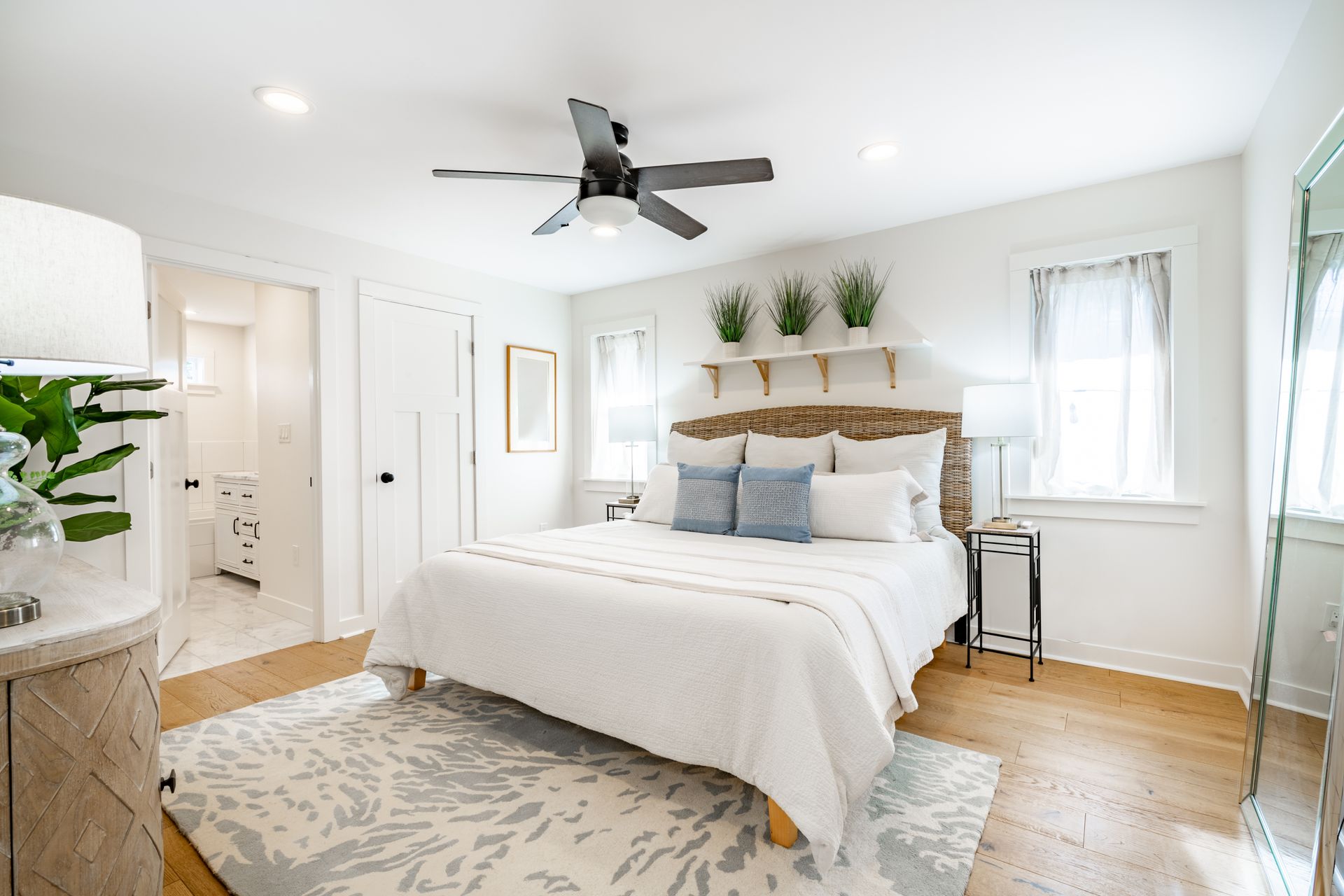 A bedroom with a large bed and a ceiling fan.