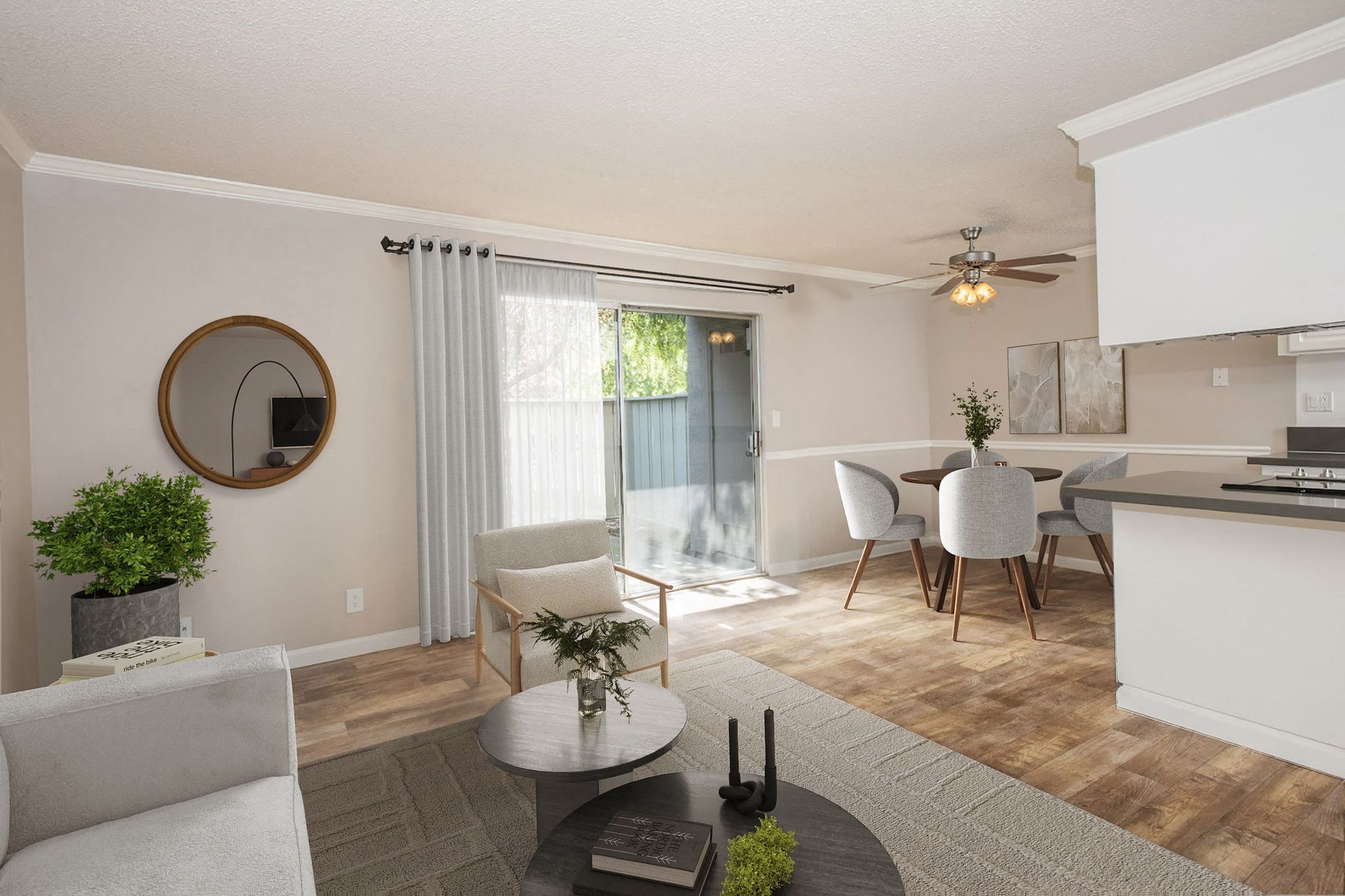 Open living room with neutral furnishings, dining area, and a sliding glass door to the patio.