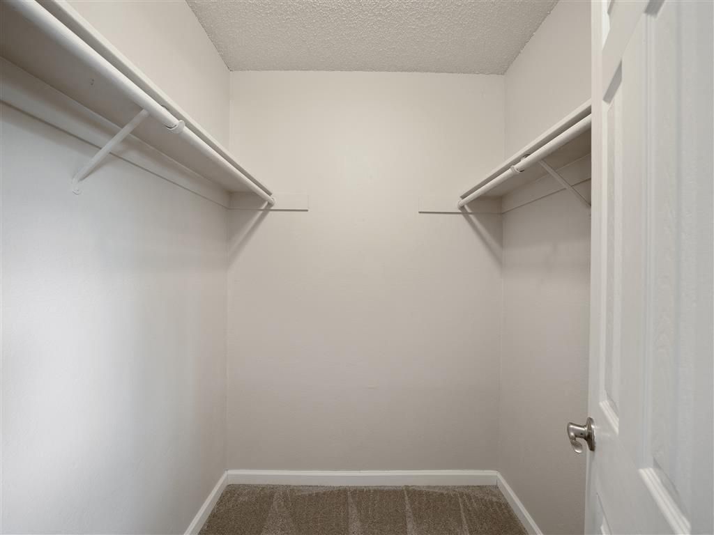 Empty walk-in closet with two clothing rods on each side