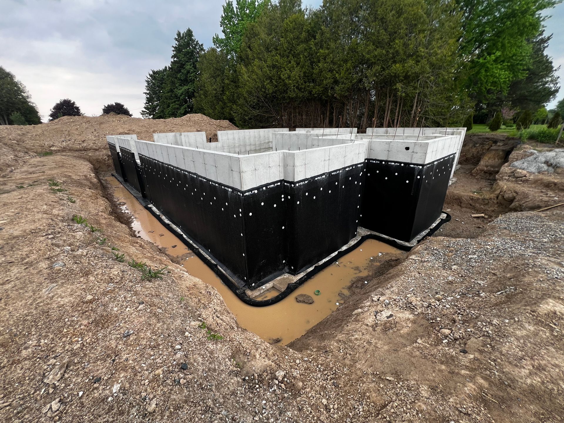 Deep excavation completed for a concrete foundation. Waterproofing membrane professionally installed.