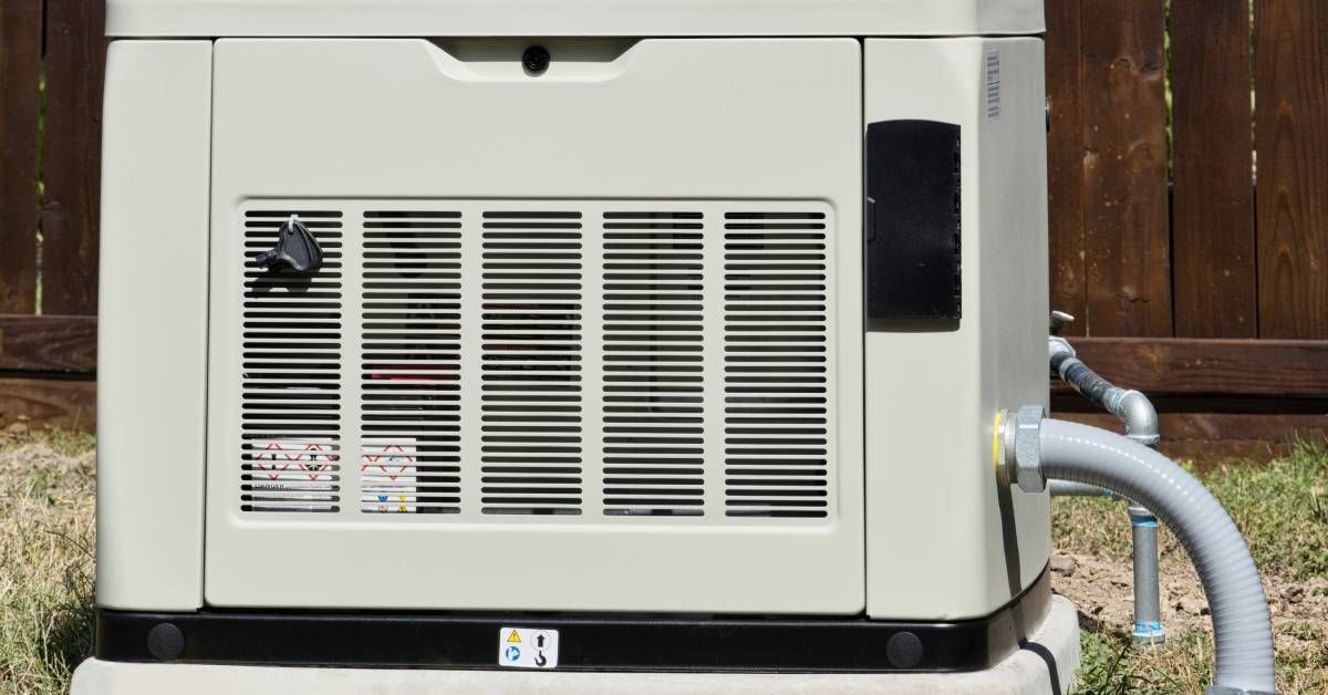 A cream-colored whole-home generator in a grassy backyard with an exhaust panel and fuel pipeline.