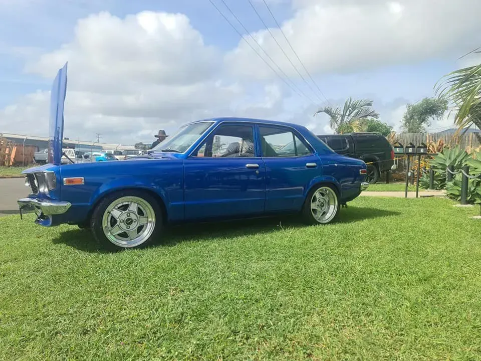 A Blue Car With The Hood Up Is Parked In The Grass — M8S Rates Mechanical In Gladstone Central, QLD