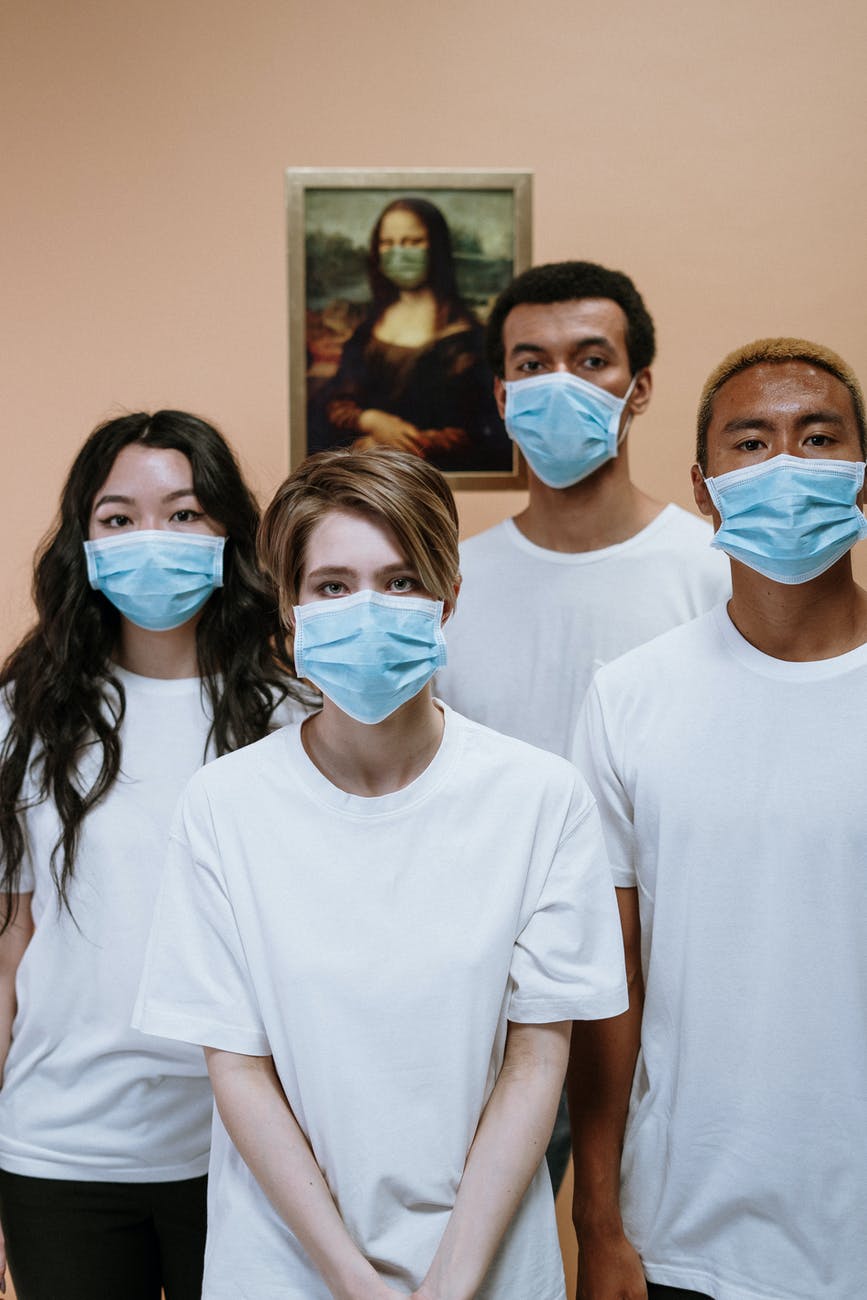 A group of people wearing face masks are posing for a picture.
