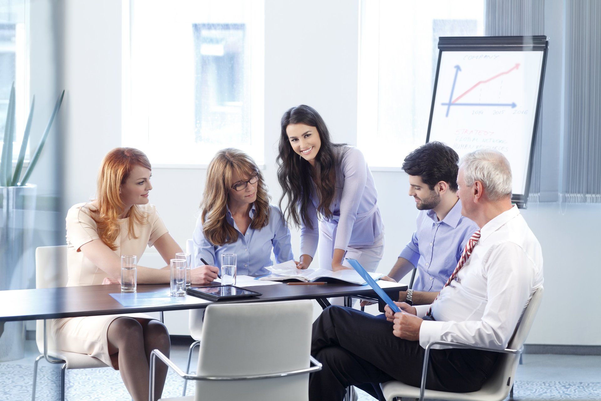 A group of people are sitting around a table having a meeting.