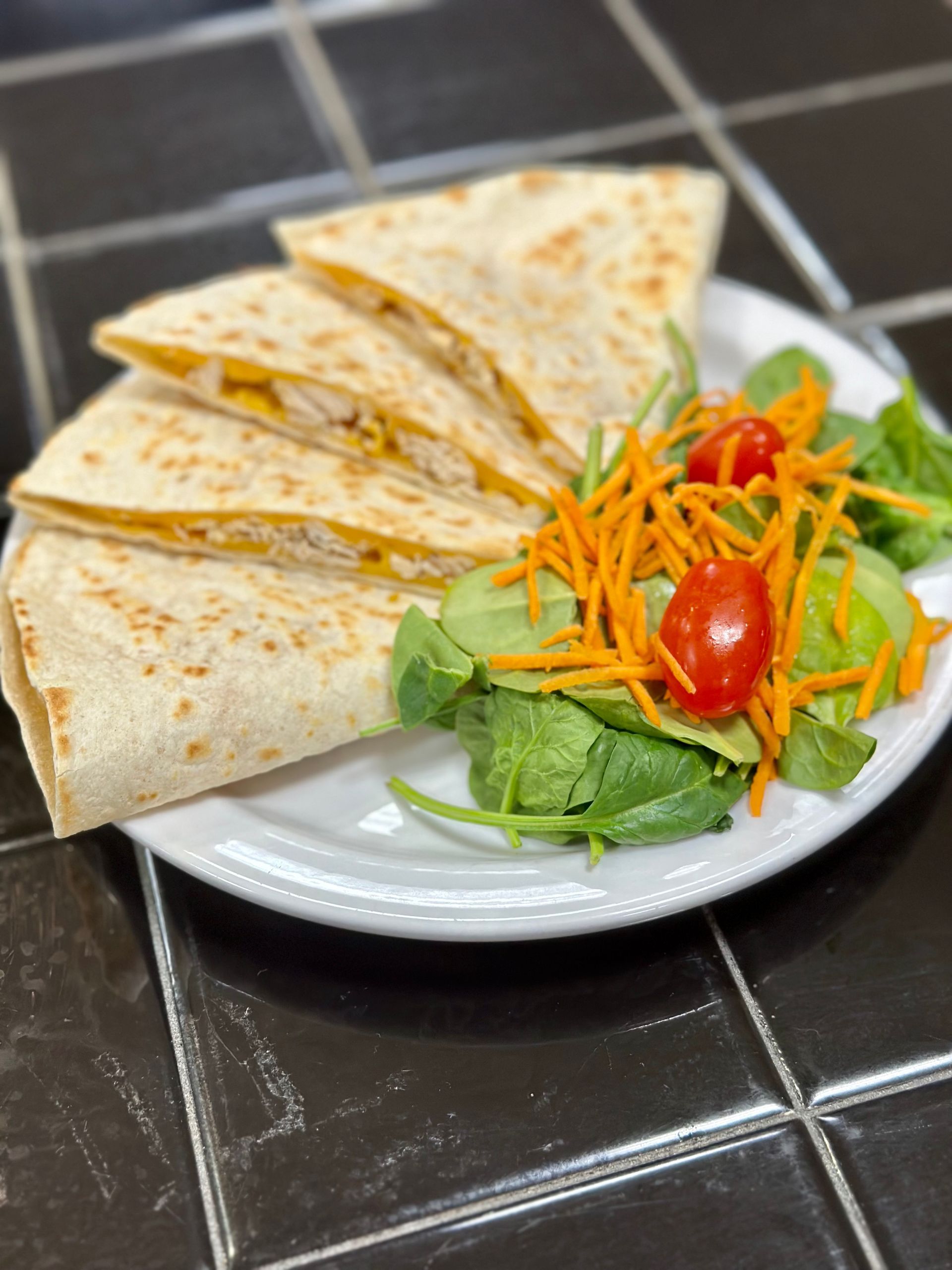 Quesadillas with side salad on a white plate.