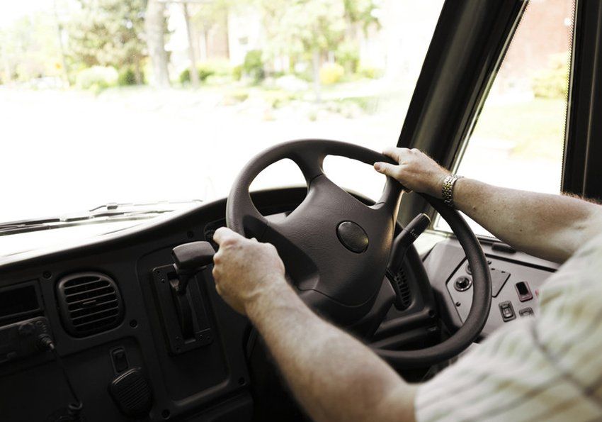 Close up of bus drivers hands on steering wheel