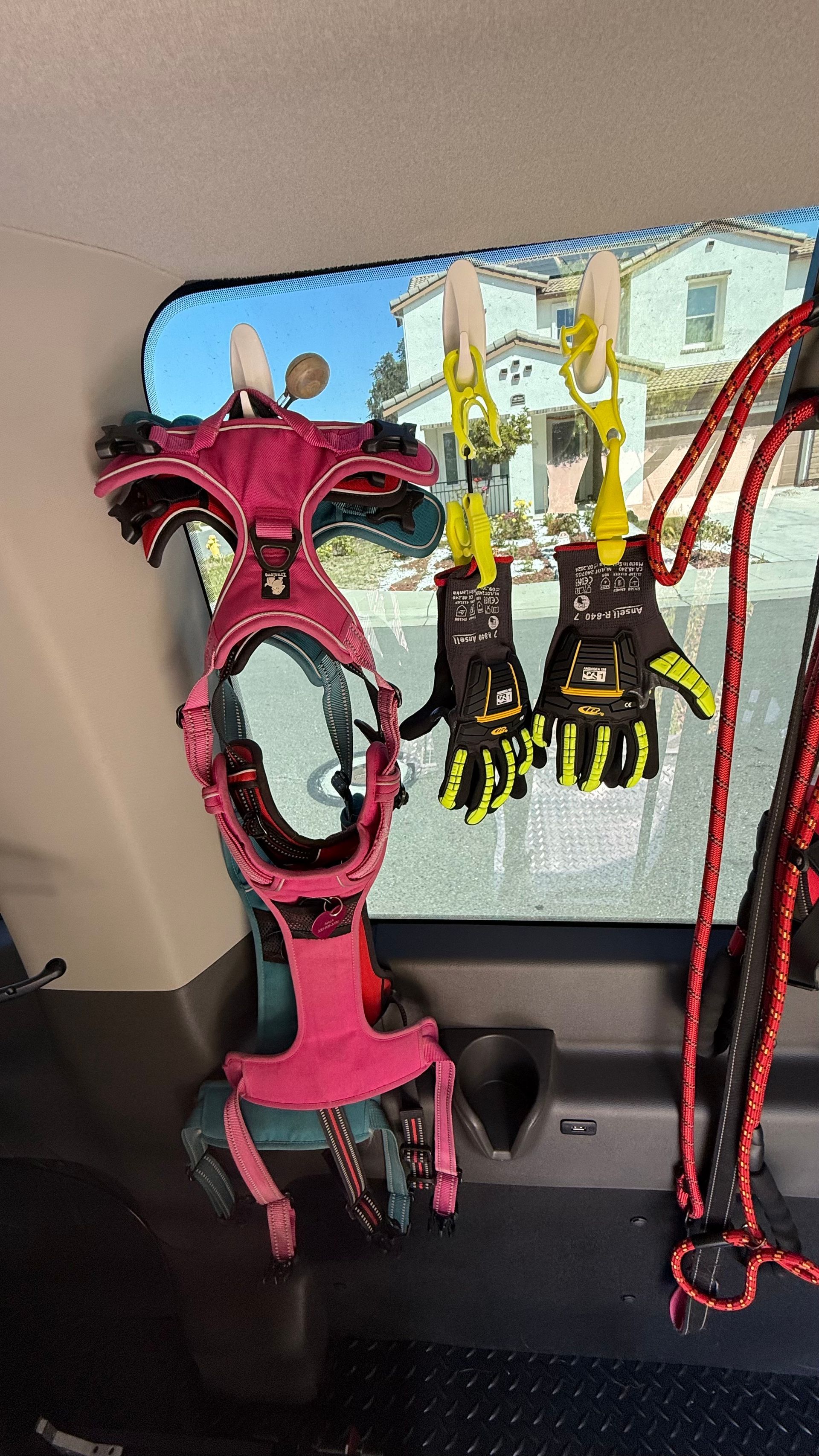 A pair of gloves hanging from a hook in the back of a car.