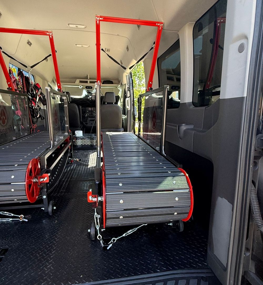 Wheelchair ramps inside a van. Black and red ramps, metal construction.