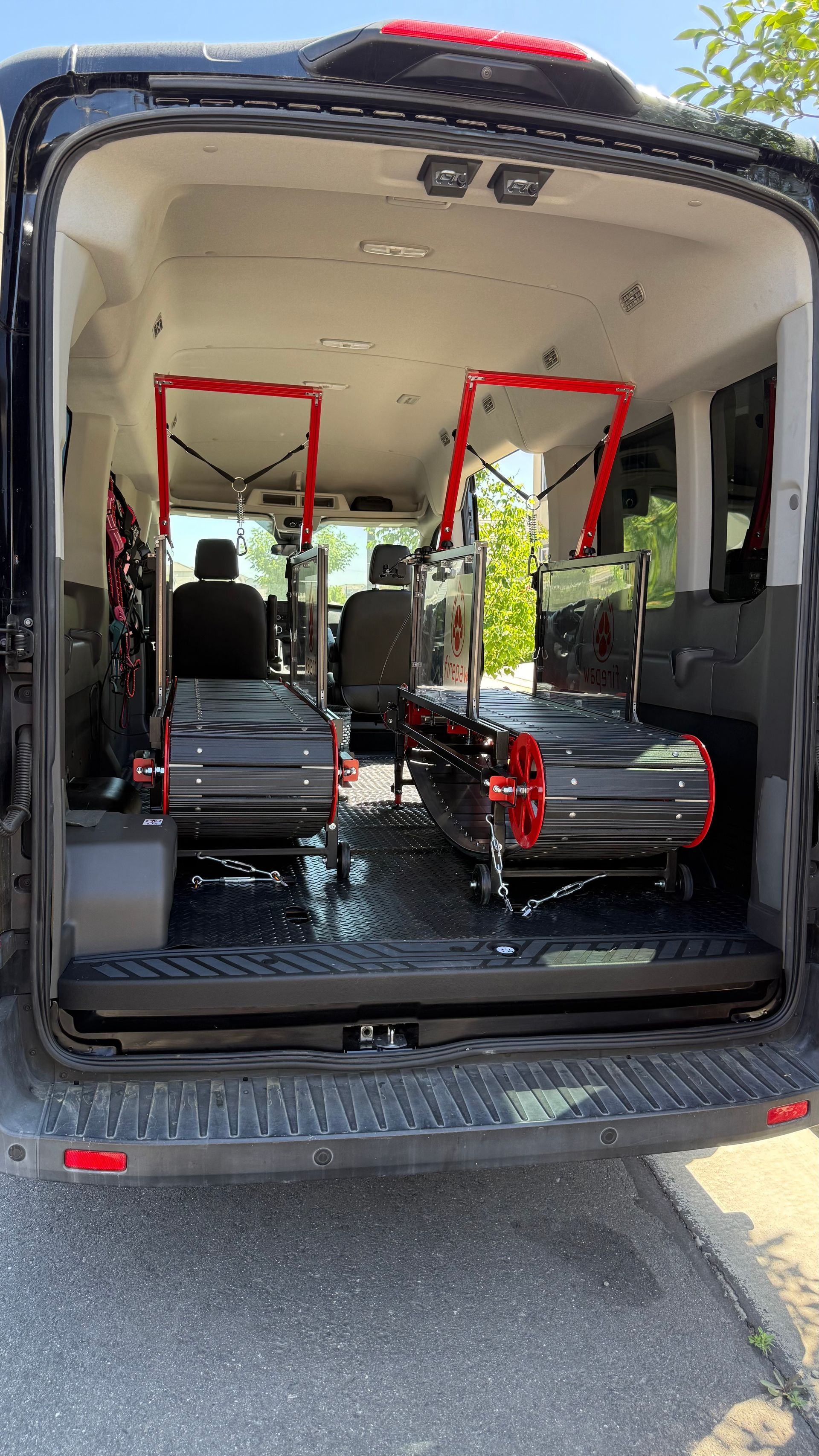 The back of an ambulance with the door open and two stretchers in the back.
