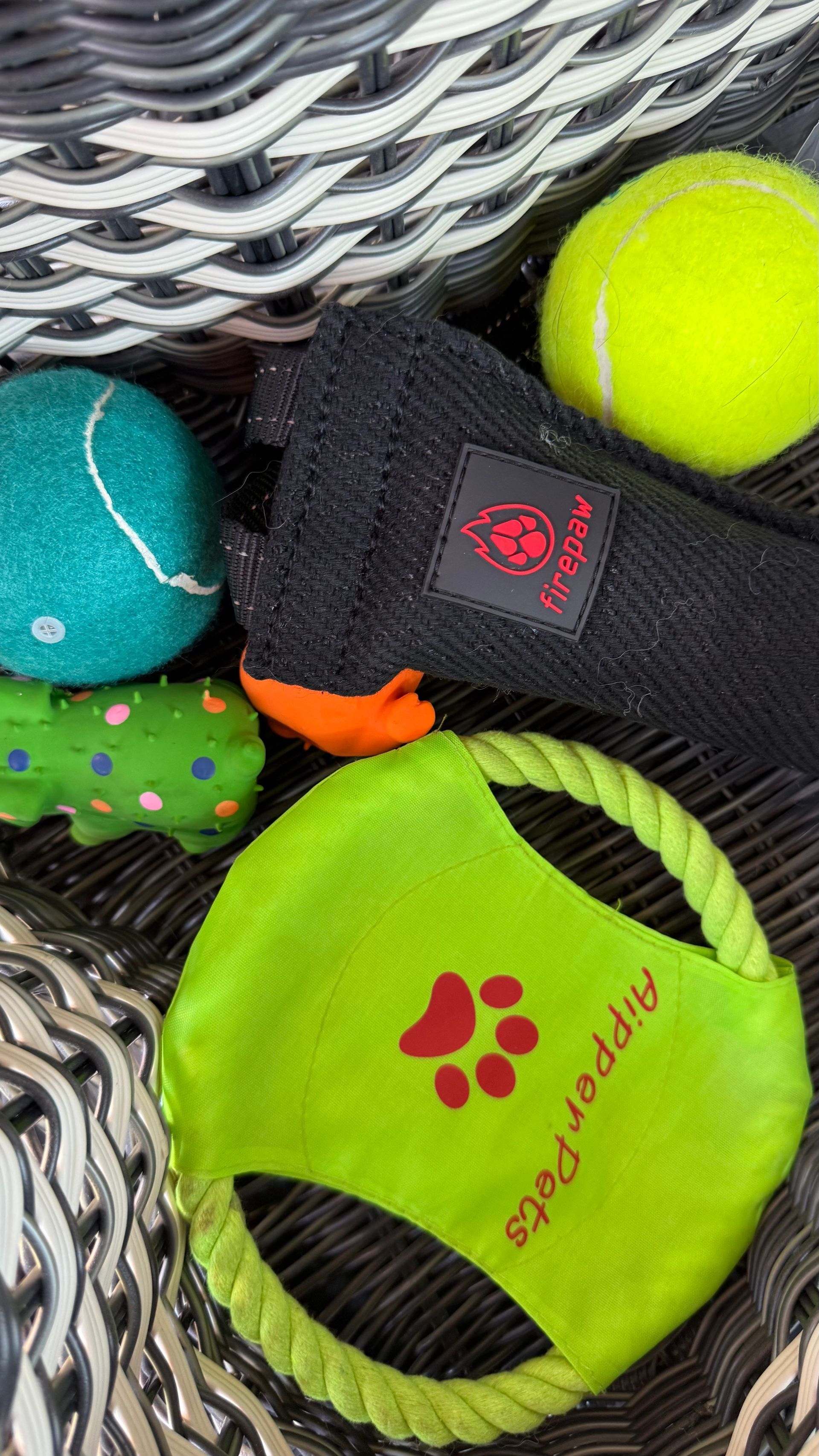A basket filled with toys and tennis balls for dogs.
