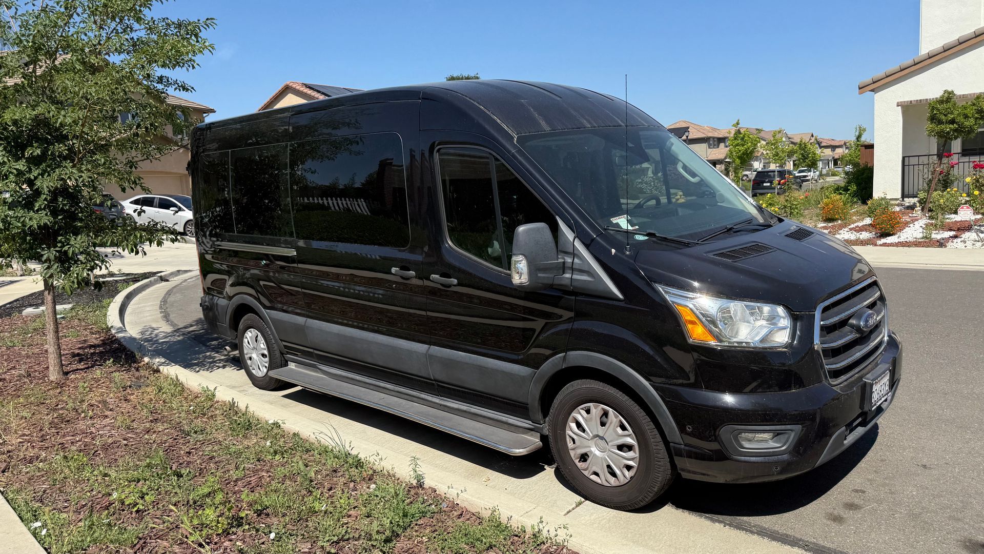 A black van is parked on the side of the road.