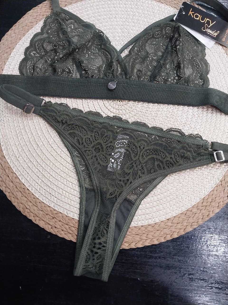 Conjunto de lencería de encaje verde sobre tapete tejido redondo.