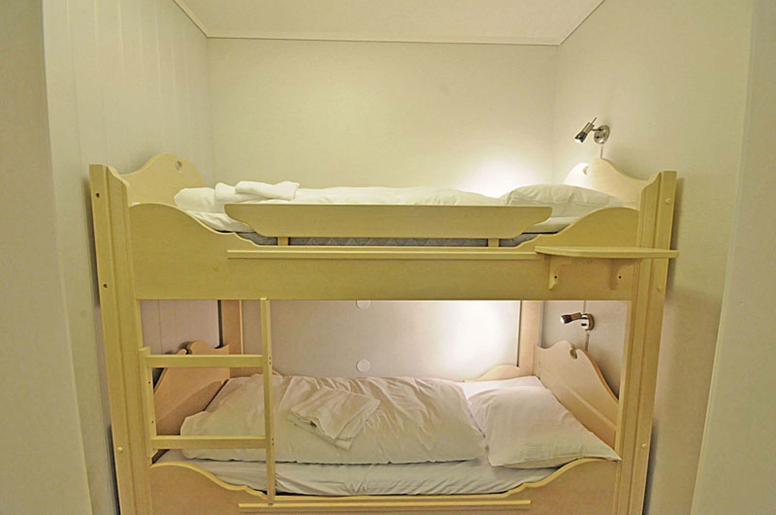 En køyeseng med to senger i et lite rom