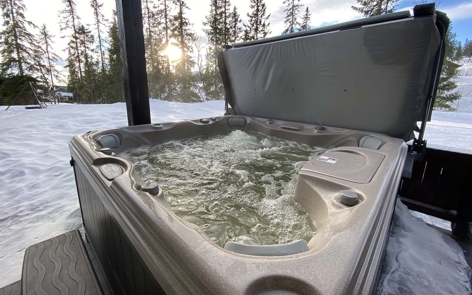 En badestamp sitter i snøen med lokket åpent.