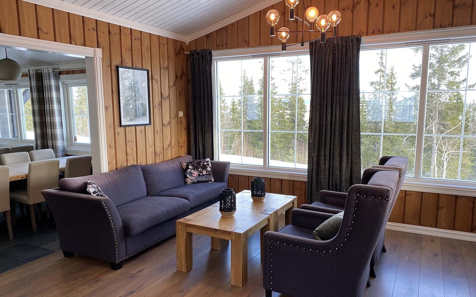 En stue med en sofa , stoler og et salongbord.