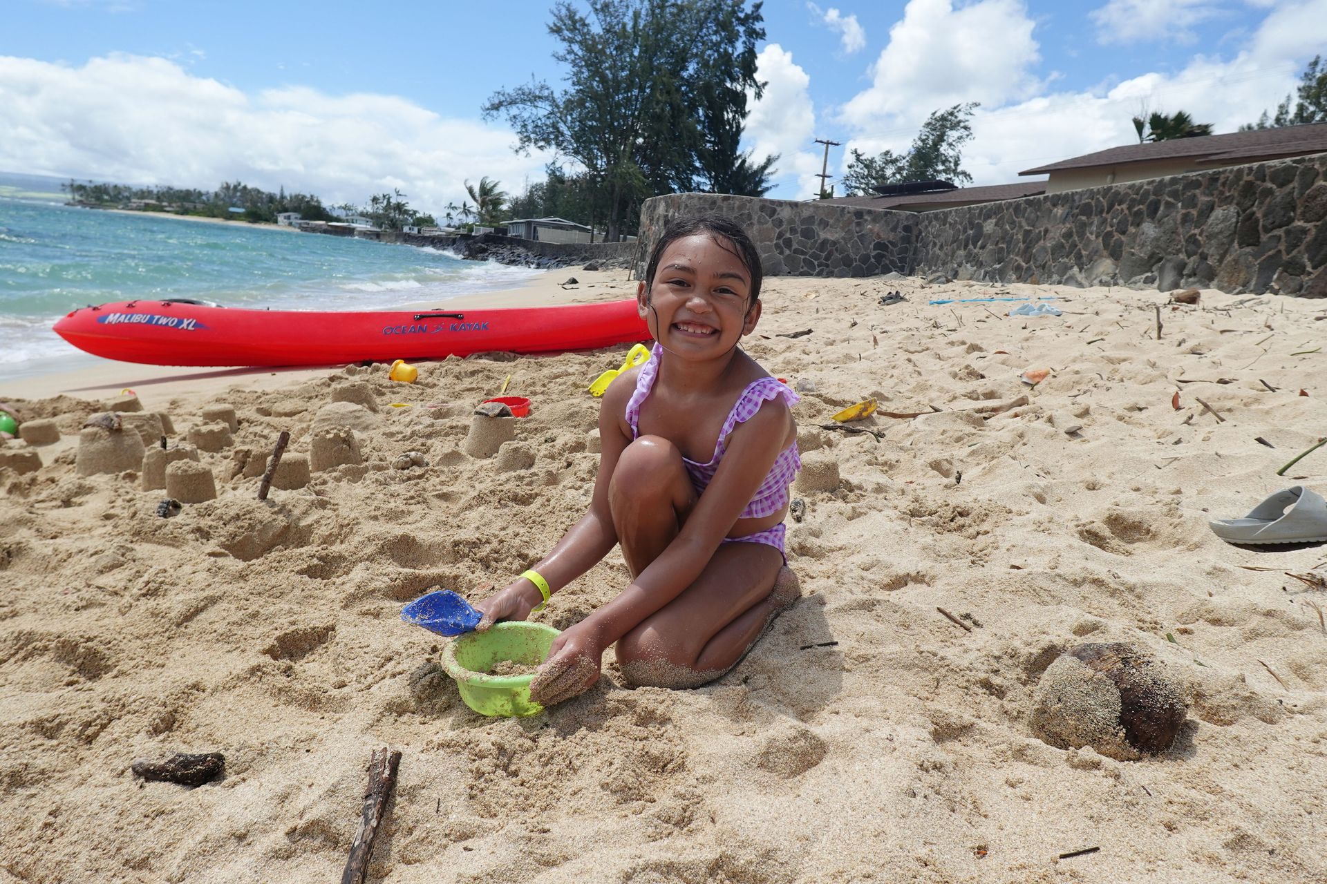 A little girl is playing in the sand on the beach