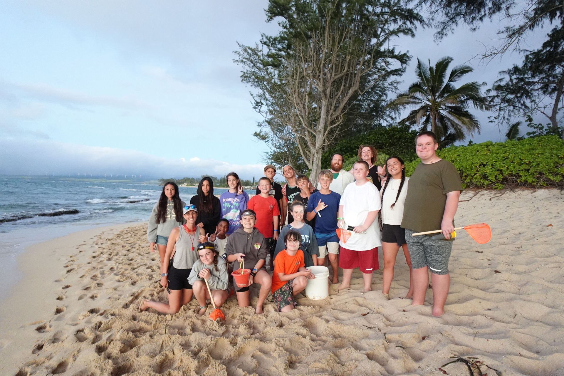 A group of people are posing for a picture on a beach.