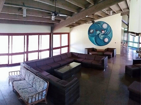 A living room with a large sectional couch and a painting on the wall