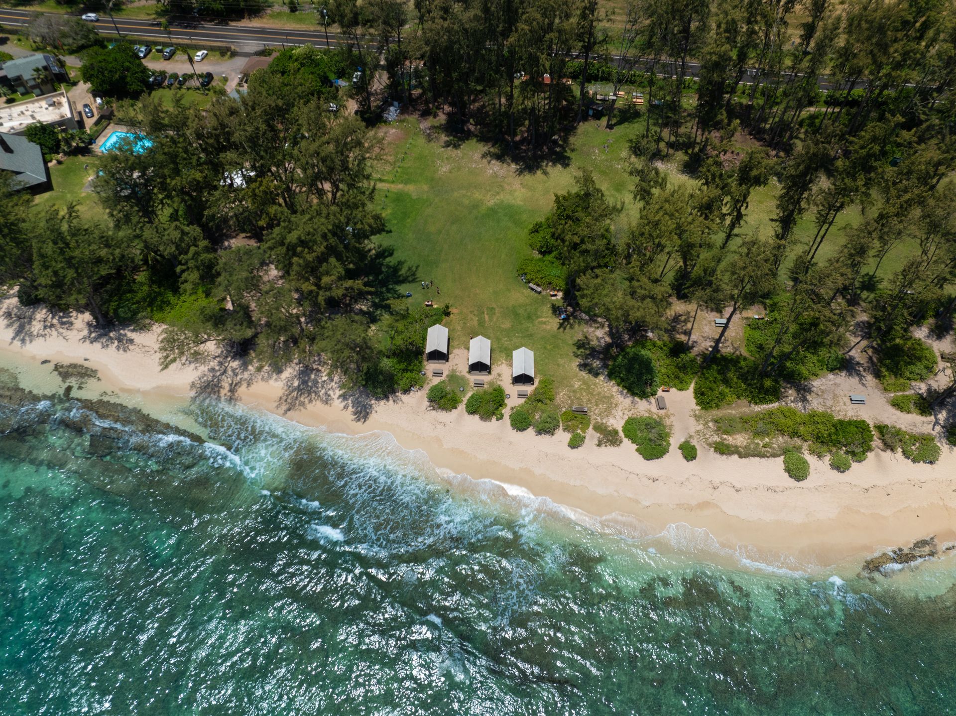 An aerial view of a beach with cars parked on it