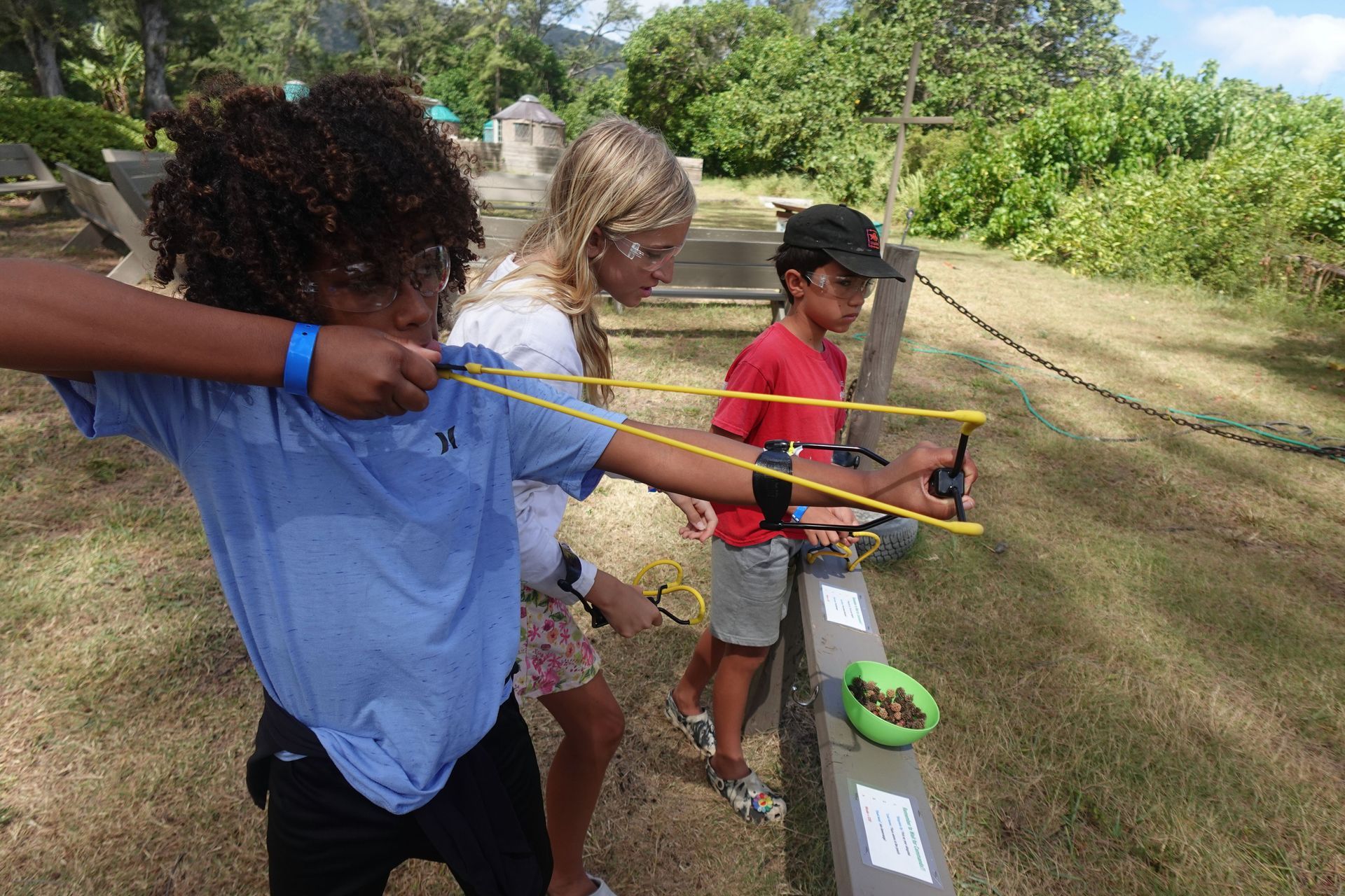 A group of children are playing with a slingshot.