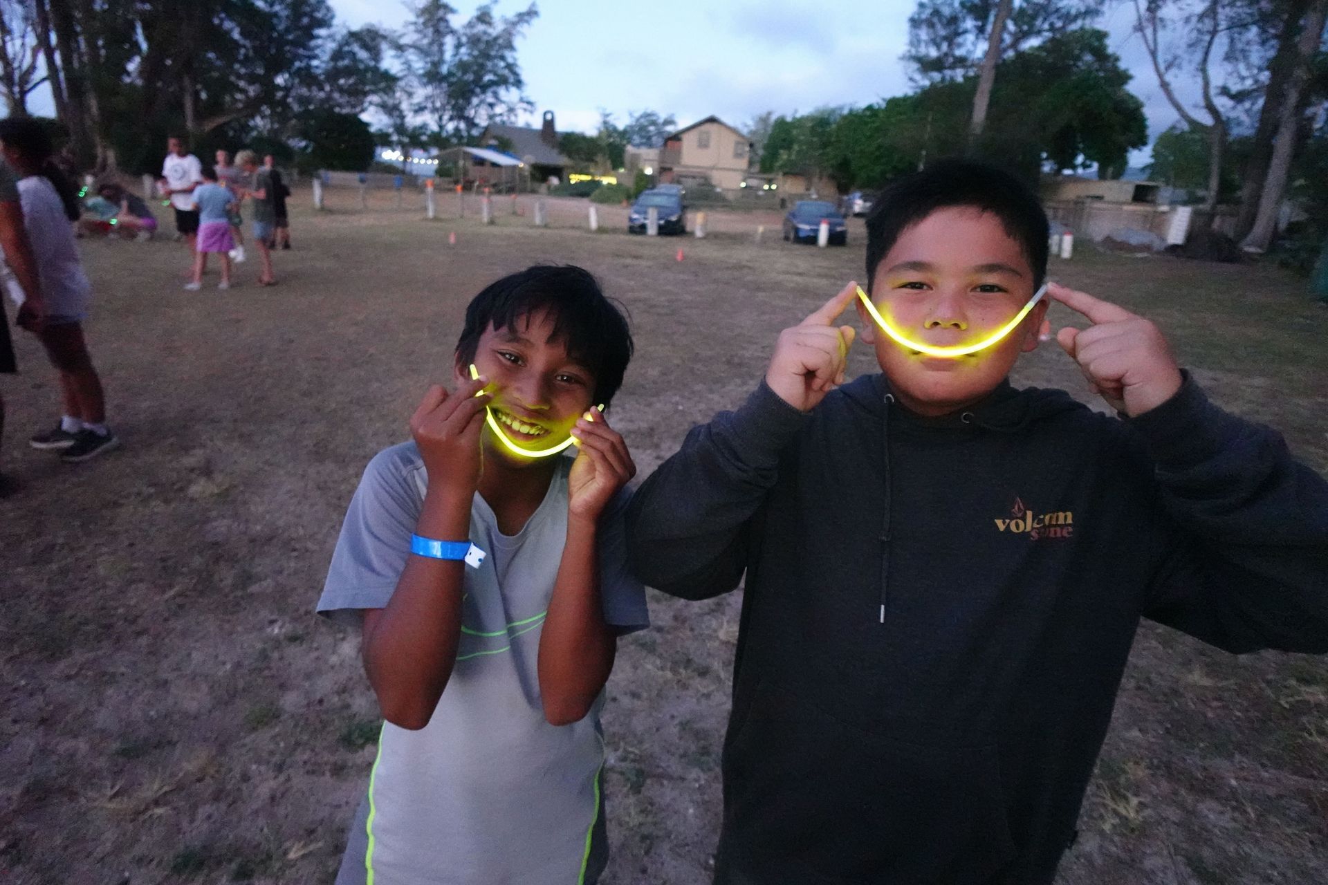 A young boy wearing a helmet and a harness is standing on a rope.